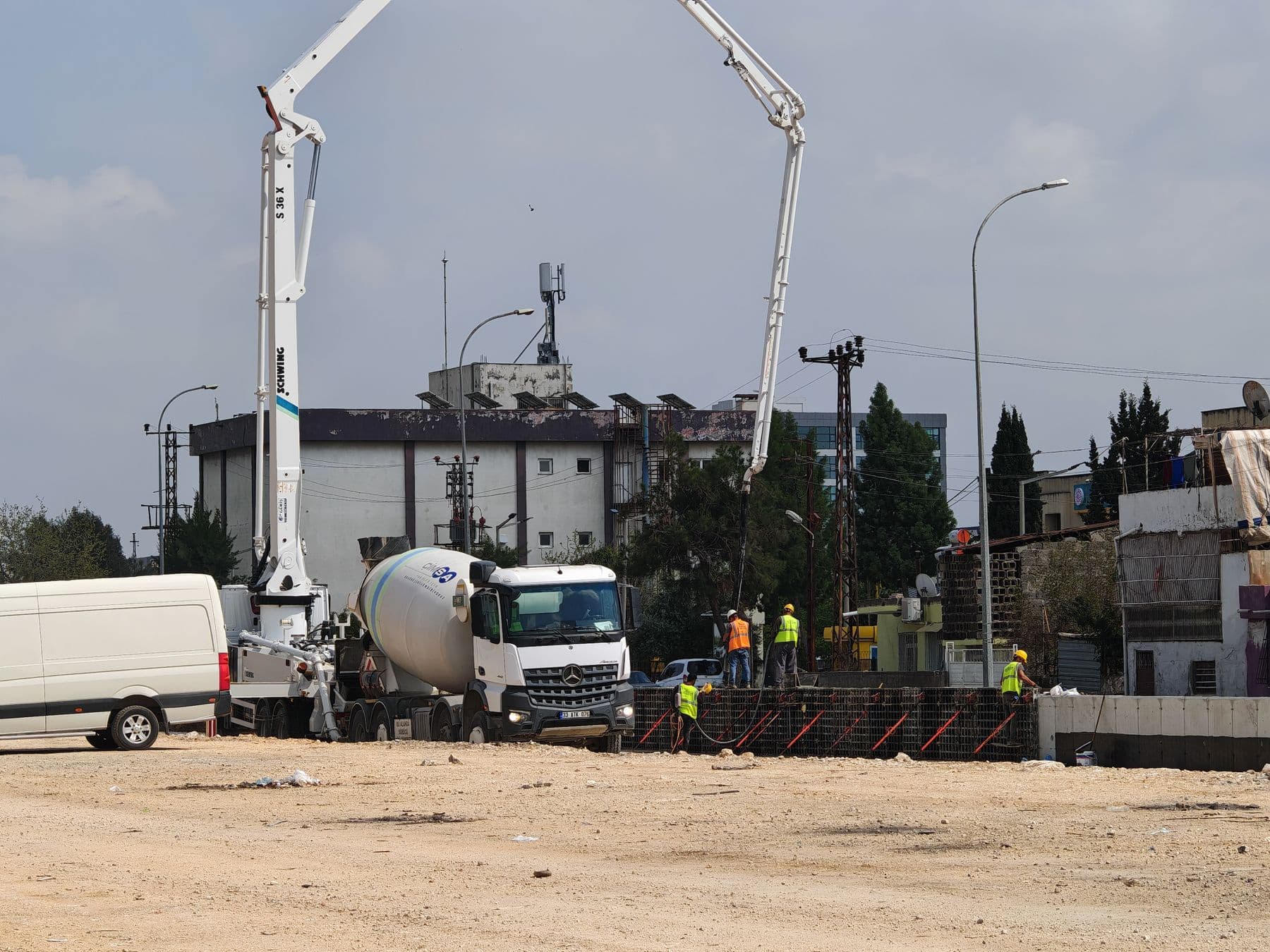 Equipe e caminhões em operação de concretagem